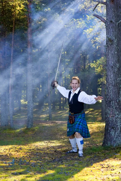 Screaming man in scottish costume with sword — Stock Photo, Image