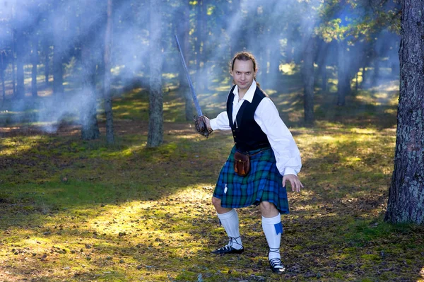 Храбрый человек в шотландском костюме с мечом — стоковое фото