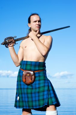 Man with naked torso in kilt clipart