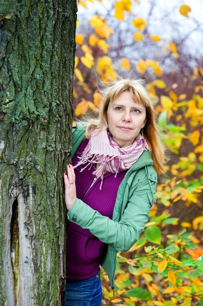 Blonde vrouw op zoek van de boom — Stockfoto