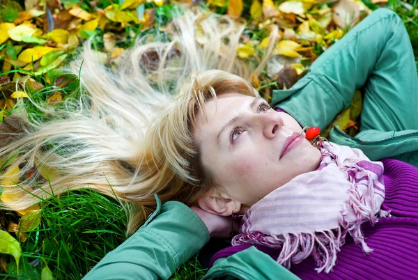 Žena ležící na trávě s berry v ústech — Stock fotografie