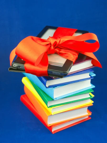 Lector electrónico de libros atado con cinta roja en la pila de libros —  Fotos de Stock