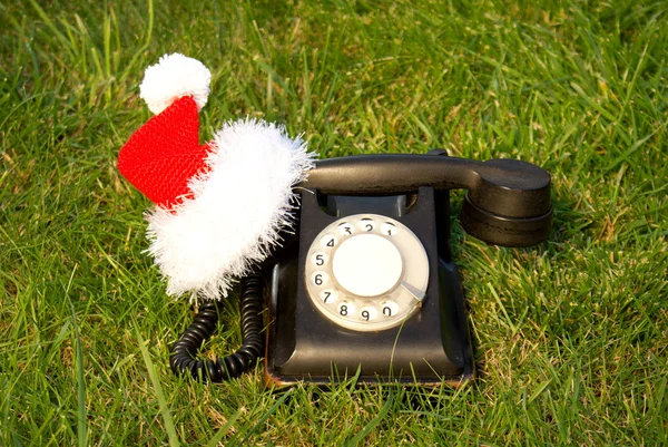 旧的老式黑色电话和圣诞老人的帽子 — 图库照片