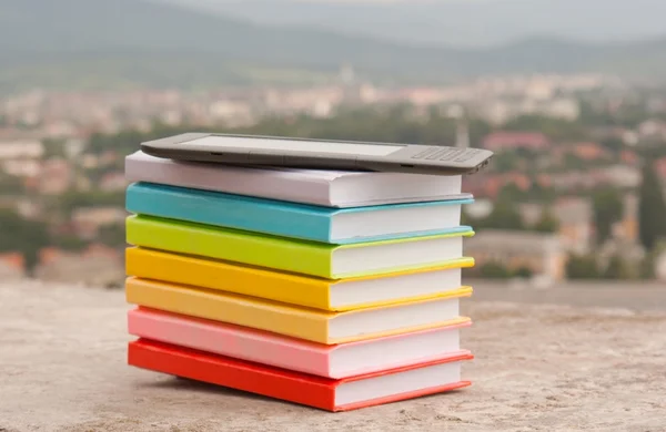 Στοίβα από πολύχρωμα βιβλία με ηλεκτρονικό αναγνώστη βιβλίων — Φωτογραφία Αρχείου