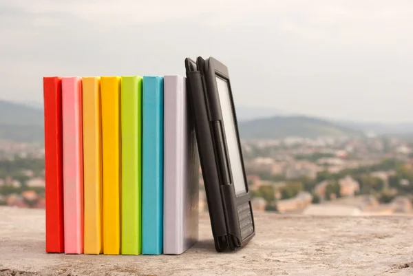 Rij van kleurrijke boeken met elektronische boek lezer — Stockfoto