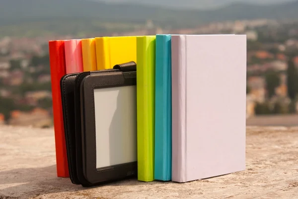 Řada barevných knih s čtečkou elektronických knih — Stock fotografie