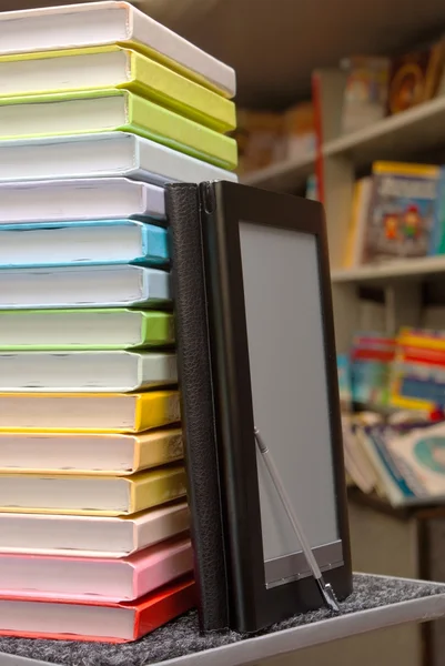 Empilement de livres colorés avec lecteur de livres électroniques — Photo