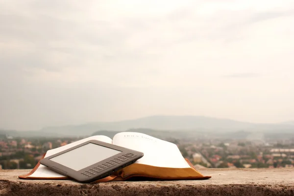 Electronic book reader laying on the book outdoors — Stock Photo, Image