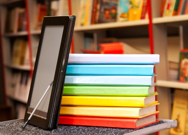 Empilement de livres colorés avec lecteur de livres électroniques — Photo