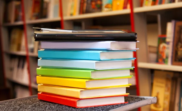 Pilha de livros coloridos com leitor de livros eletrônicos — Fotografia de Stock