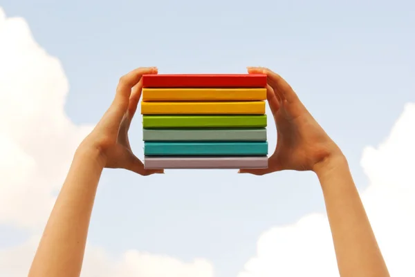 Handen met kleurrijke hard dekken boeken — Stockfoto