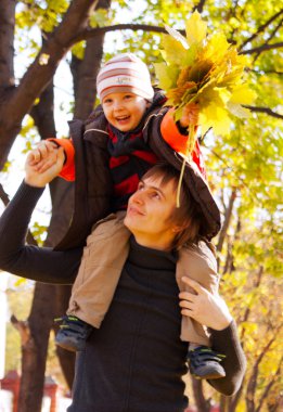 Happy father and son at fall time clipart