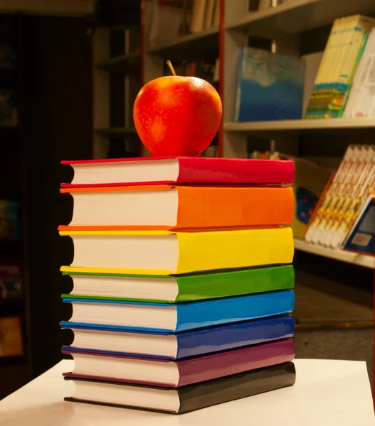 Stapel bunter Bücher mit einem Apfel drauf — Stockfoto