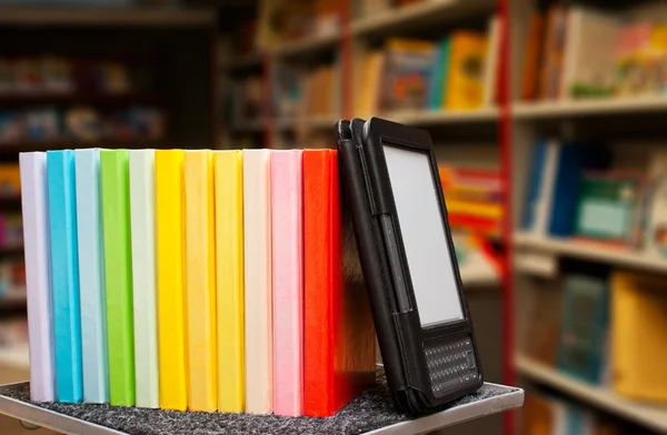 Σειρά από πολύχρωμα βιβλία με ηλεκτρονικό αναγνώστη βιβλίων — Φωτογραφία Αρχείου