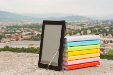 elektronik kitap okuyucu ile renkli kitap yığını