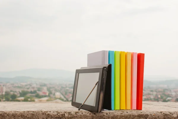Wiersz kolorowych książek z czytnika książek elektronicznych — Zdjęcie stockowe