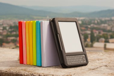 Row of colorful books with electronic book reader clipart