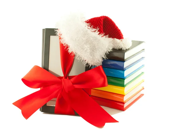 Lector electrónico de libros con sombrero de Santa Claus y pila de libros —  Fotos de Stock