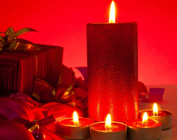 蜡烛和礼品在红色背景 — 图库照片