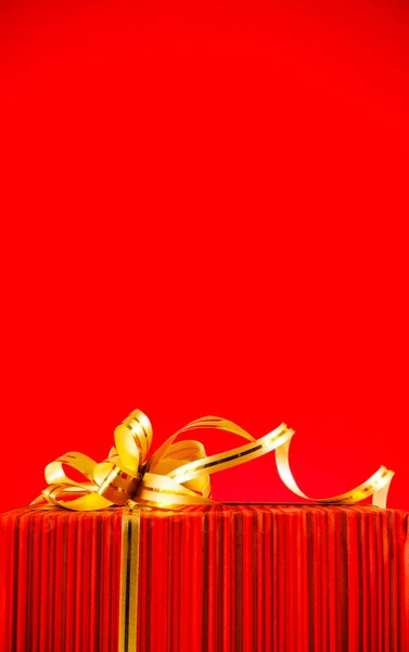 Caixa embrulhada contra fundo vermelho — Fotografia de Stock