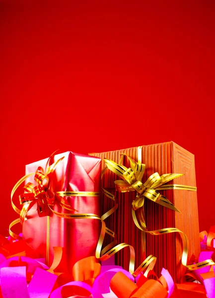 Geschenke in roten Schachteln vor rotem Hintergrund — Stockfoto