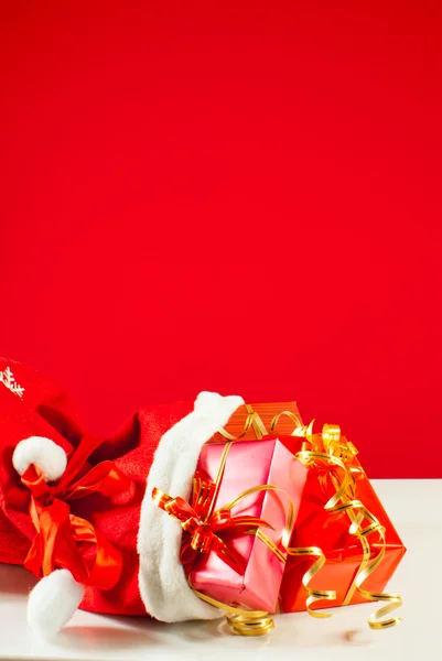 赤い背景に対してバッグにクリスマス プレゼントします。 — ストック写真