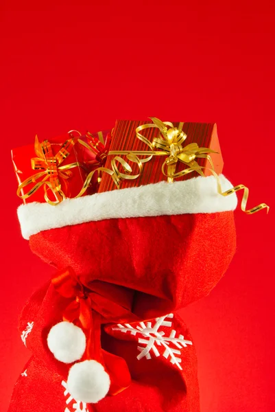 Regali di Natale nella borsa sullo sfondo rosso — Foto Stock
