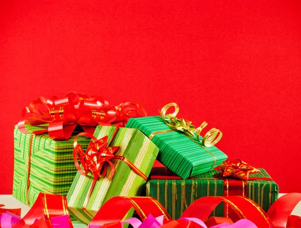 Scatole avvolte con regali sullo sfondo rosso — Foto Stock