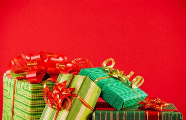 Scatole avvolte con regali sullo sfondo rosso — Foto Stock