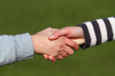 Closeup picture of teenagers shaking hands. clipart