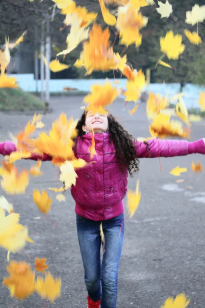 Vicces fiatal lány a szabadban játszani a levelek — Stock Fotó