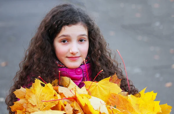 黄色叶子的漂亮年轻女孩的肖像 — 图库照片