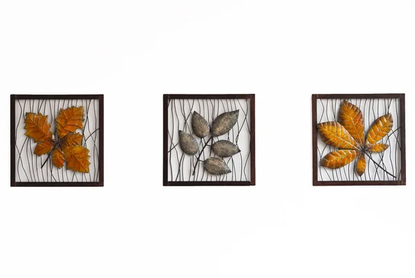 Tre foglie di metallo nel quadrato isolato su parete bianca — Foto Stock