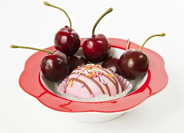 Tasse Kuchen in roter Schüssel mit frischer Kirsche isoliert auf weißem Hintergrund — Stockfoto
