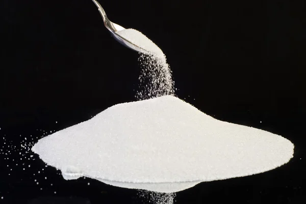 Heap of sugar and a teaspoon — Stock Photo, Image