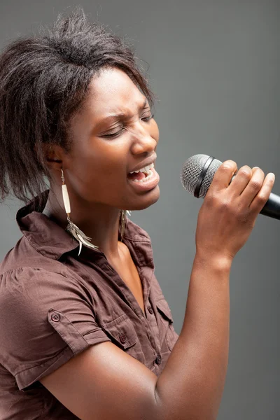 Mujer negra cantando en el micrófono — Foto de Stock