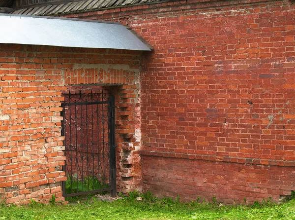 Открытые ворота в кирпичной стене — стоковое фото