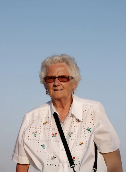 Una señora mayor con fondo de cielo azul —  Fotos de Stock