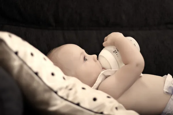 Een zes maanden oude baby drinken uit zijn fles — Stockfoto