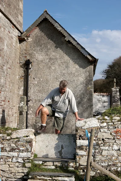 Volwassen man klimmen over een muur — Stockfoto