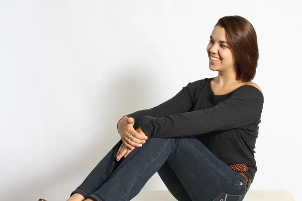 Krásná mladá žena sedící — Stock fotografie