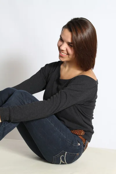 Krásná mladá žena sedící — Stock fotografie