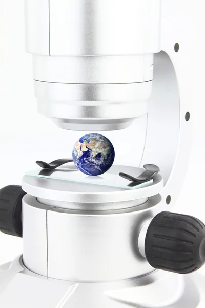 Microscópio com o globo na plataforma de visualização — Fotografia de Stock