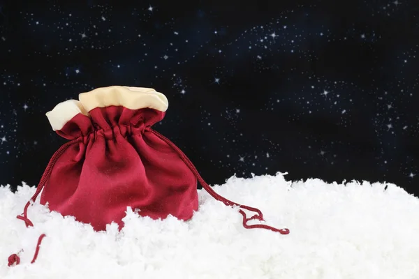 Rode satijnen zak op sneeuw — Stockfoto