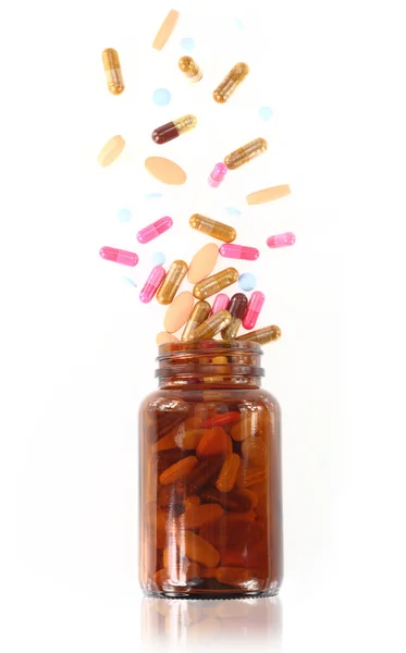 Comprimidos saem de um frasco de medicamentos — Fotografia de Stock