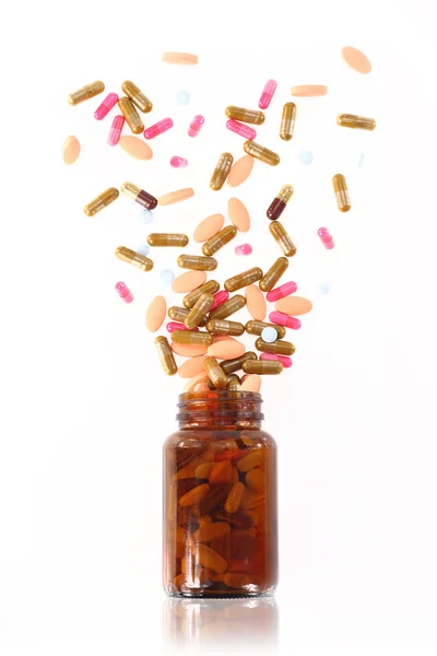 Таблетки выходят из бутылки с лекарством — стоковое фото