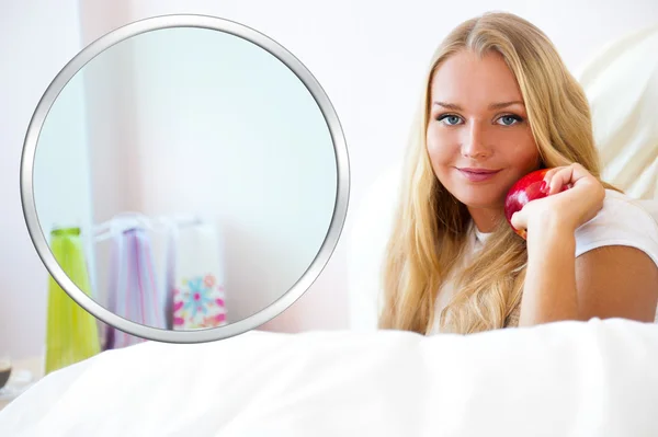 Jonge mooie vrouw met apple in bed in de ochtend — Stockfoto
