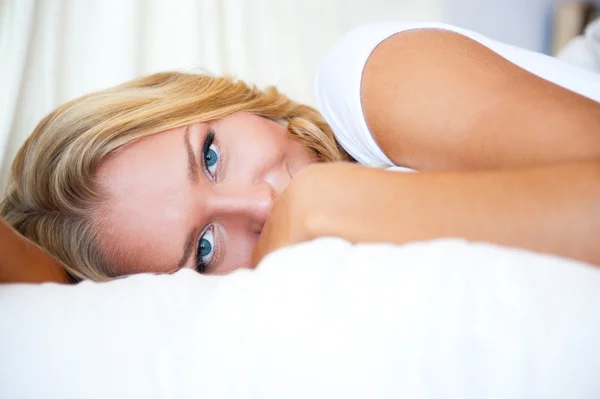 Портрет красивой улыбающейся женщины на кровати в спальне — стоковое фото