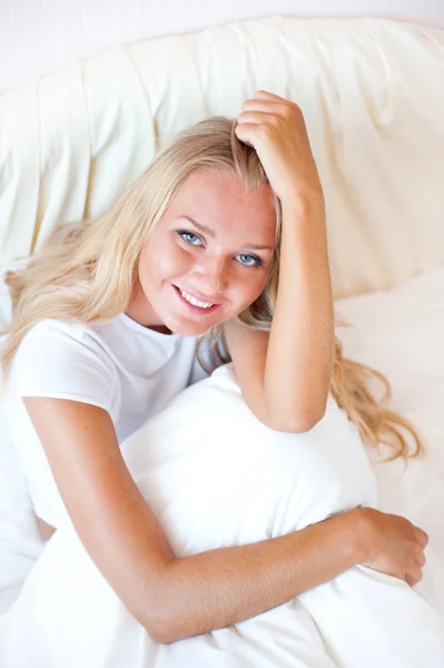 Mladá blondýna se těší slunné ráno v posteli — Stock fotografie
