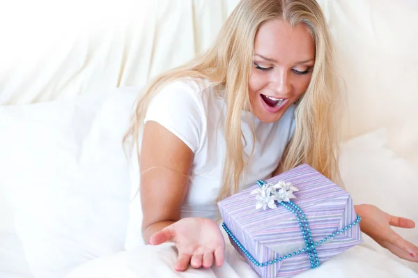 Yatak odası sürpriz hediyesi - mutlu kadın yatak odasında — Stok fotoğraf